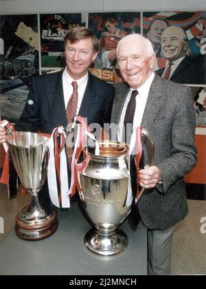 Alex Ferguson, Manager von Manchester United, und Sir Matt Busby, ehemaliger Manager von Manchester United, posieren mit den europäischen Trophäen, die sie als United Manager gewonnen haben. Ferguson gewann den Pokalsieg nach dem Sieg seiner Mannschaft über Barcelona im Mai 1991 und Busby gewann die Trophäe des European Champions Cup, nachdem seine Mannschaft Benfica im Finale 1968 in Wembley besiegt hatte. 18.. Oktober 1991. Stockfoto