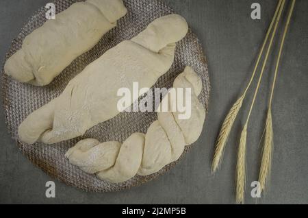 Sauerteig-Brotgärung, grauer Hintergrund mit getrockneter Weizenblume Stockfoto