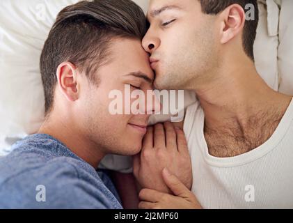 Hes meine bessere Hälfte. Aufnahme eines jungen schwulen Paares, das sich im Bett entspannt. Stockfoto