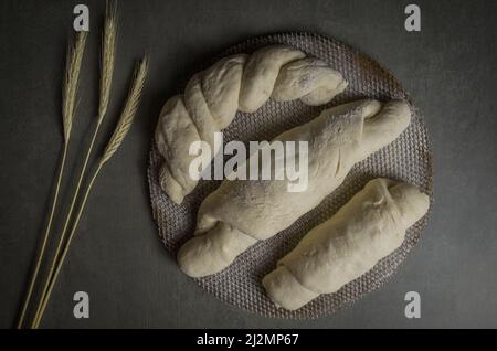 Sauerteig-Brotgärung, grauer Hintergrund mit getrockneter Weizenblume Stockfoto