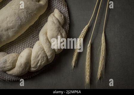 Sauerteig-Brotgärung, grauer Hintergrund mit getrockneter Weizenblume Stockfoto