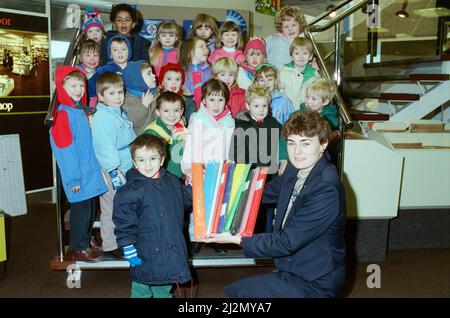 Luke Walker, von der Martsden Nursery School, wird mit Klassenkameraden gesehen, die W H Smith¿ Geschäft in Huddersfield besucht haben, wobei die stellvertretende Geschäftsführerin Frau Alison Ledger ein anderes farbliches Papier zeigte. Der Besuch war Teil¿neuesten Themenprojekts der Schüler auf Papier. Sie haben sich Zeitungen, verschiedene Papiersorten und die Verwendung von Papier angesehen. Sie haben Modelle hergestellt und in ihrer kreativen Arbeit anderes Papier verwendet. Bei Smith¿ wurde ihnen die Palette der im Handel angebotenen Papierprodukte gezeigt. 4.. Februar 1991. Stockfoto