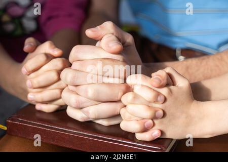 Kinder beten zu Hause mit den Eltern, Familie beten zusammen, Online-Gruppenanbetung, Weltgebetstag, Internationaler Tag des Gebets, Hoffnung, Dankbarkeit Stockfoto