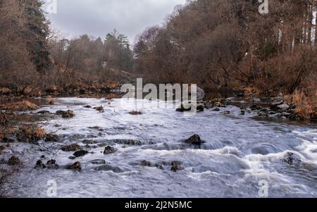 Das Wasser von Deugh fließt durch Dundeugh unterhalb des Polmaddy Burn-Zusammenflusses im Winter, Dumfries und Galloway, Schottland Stockfoto