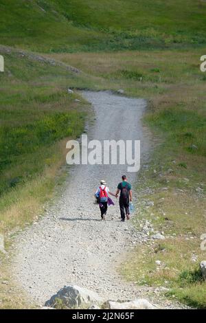 Junge Paar Wanderer mit Rucksack gehen Hand in Hand auf steinigen Weg, Montenegro Stockfoto