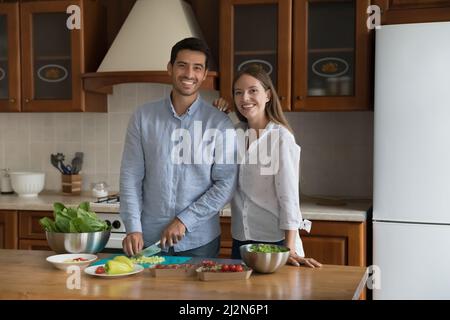 Glückliche Blogger hacken frisches Gemüse für Salat in der heimischen Küche Stockfoto