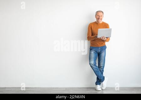 Selbstbewusster, reifer Mann, der zu Hause einen Laptop verwendet Stockfoto