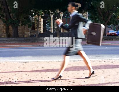 Beschäftigte Geschäftsfrau. Bewegungsunschärfe einer Geschäftsfrau, die durch die Stadt läuft. Stockfoto