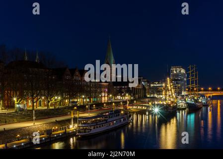 Nachtansicht von Bremen mit den Gebäuden, Brücken und Schiffen, die sich im Fluss spiegeln Stockfoto