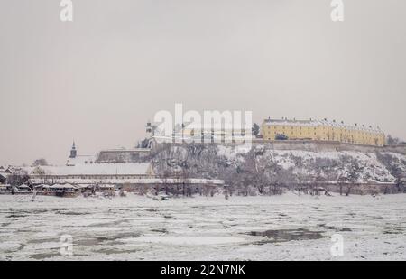 Novi Sad, Serbien - 23. Januar 2014: Festung Petrovaradin vom Ufer der Donau im Winter durch Nebel. Stockfoto