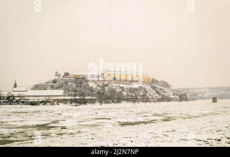 Novi Sad, Serbien - 23. Januar 2014: Festung Petrovaradin vom Ufer der Donau im Winter durch Nebel. Stockfoto