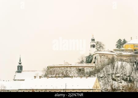 Novi Sad, Serbien - 23. Januar 2014: Festung Petrovaradin vom Ufer der Donau im Winter durch Nebel. Stockfoto