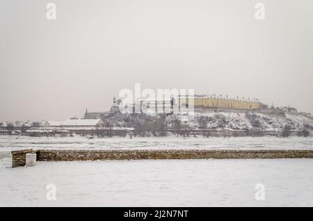 Novi Sad, Serbien - 23. Januar 2014: Festung Petrovaradin vom Ufer der Donau im Winter durch Nebel. Stockfoto