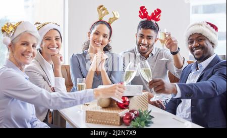 Der festliche Geist ist offiziell eingetreten. Aufnahme einer Gruppe von Geschäftsleuten, die gemeinsam auf ihrer Weihnachtsfeier im Büro feiern. Stockfoto