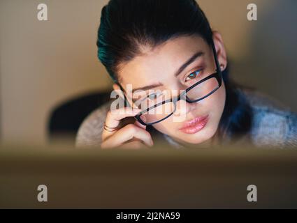 Er arbeitet hart für diese Promotion. Aufnahme einer jungen Geschäftsfrau im Büro. Stockfoto