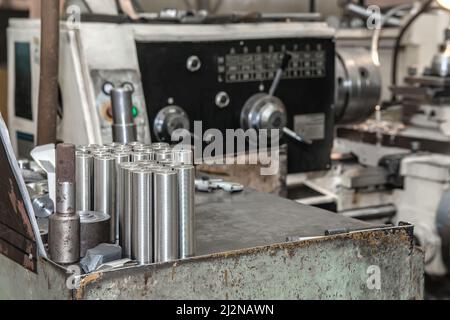 Metallwerkstücke nach dem Drehen und Fräsen auf der Zahnstange . Metallabsagearbeiten auf einer Drehmaschine. Metallverarbeitende Industrie. Veredelung oder Schleifen einer Stockfoto