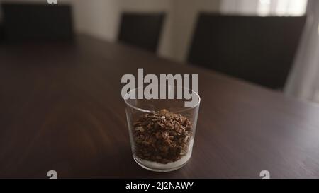 Granola mit Joghurt im Glas auf Holztisch machen, breites Foto Stockfoto