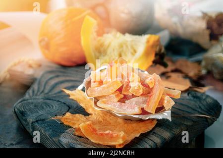 Vorbereitung von natürlichen Bauernhof hausgemachte kandierte Kürbisfrüchte mit Puderzucker bestreut. Getrocknete kandierte Kürbisfrüchte Stockfoto