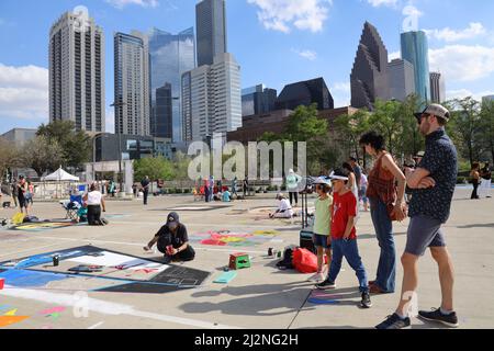 Houston, USA. 2. April 2022. Menschen beobachten, wie ein Künstler bei einem Street Painting Kreide Art Festival in Houston, Texas, USA, am 2. April 2022 malt. Quelle: Xu Jianmei/Xinhua/Alamy Live News Stockfoto