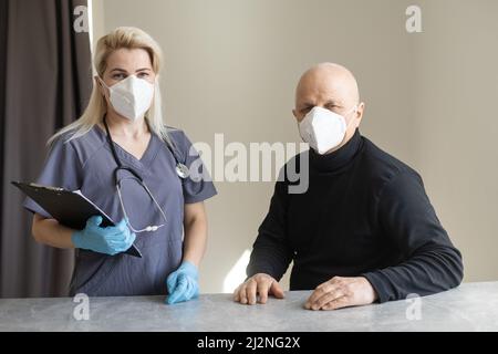 Junge Krankenschwester, die sich um einen alten kranken Mann kümmert Stockfoto