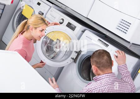 Positive Familie entscheidet sich für neue Waschmaschine im Laden Stockfoto