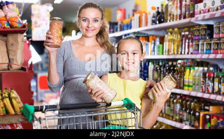 Mutter mit Teenager-Mädchen, die ihre Auswahl beim Essen demonstrierten Stockfoto