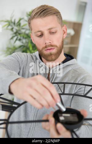 Mann, der die Batterie in seiner Uhr ersetzt Stockfoto