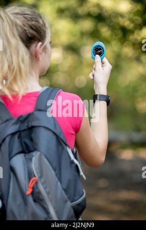 Portrait eines attraktiven blonden Mädchens mit einem Kompass im Freien Stockfoto