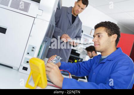 Ein Elektriker überprüft den Drucker Stockfoto