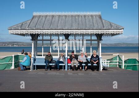 Bunte Szenen von Urlaubern, die sich auf der Esplanade-Promenade von Weymouth mit Blick auf die Weymouth Bay entspannen Stockfoto