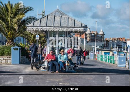 Bunte Szenen von Urlaubern, die sich auf der Esplanade-Promenade von Weymouth mit Blick auf die Weymouth Bay entspannen Stockfoto