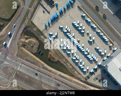 Logistikdepot für die Lieferkette von oben nach unten. Luftdrohnenansicht eines kommerziellen Lagerhauses Lieferwagen verteilen Waren. Amsterdam Stockfoto