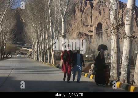 (220403) -- AFGHANISTAN, 3. April 2022 (Xinhua) -- Menschen gehen in der Nähe der Bamiyan Buddha Statue in Bamiyan, Zentralafghanistan, 16. März 2022. ZUM ARTIKEL „Feature: Afghanen wollen riesige Buddha-Statuen in Bamiyan restaurieren sehen“ (Foto: Saifurahman Safi/Xinhua) Stockfoto