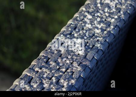 Nahaufnahme von Frost-/Eis-/Hagelsteinen auf Gartenmöbeln Stockfoto