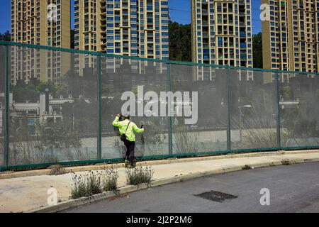 Hongkong, China. 03. April 2022. Ein Mann spricht, während er seine Verwandten durch ein Fernglas in Shenzhen über den Grenzzaun bei Heung Yuen Wai in Hongkong beobachtet. An der Grenze zwischen Hongkong und Shenzhen gelegen, ist Hung Yuen Wai einer der Orte, an dem Familien, die aufgrund von Reisebeschränkungen zwischen Covid-19 und der Grenze getrennt sind, einander sehen können. Kredit: SOPA Images Limited/Alamy Live Nachrichten Stockfoto