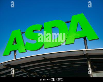 Corporate Signage in einem Geschäft der britischen ASDA-Supermarktkette. An einem sonnigen Tag gegen einen wolkenlosen, blauen Himmel aufgenommen. Stockfoto