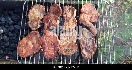 Gegrillte Schweinesteaks, Schweinehals mit Zusatz von Kräutern und Gewürzen auf der Grillplatte, Draufsicht, gegrilltes Fleisch, bbq, Grill Stockfoto