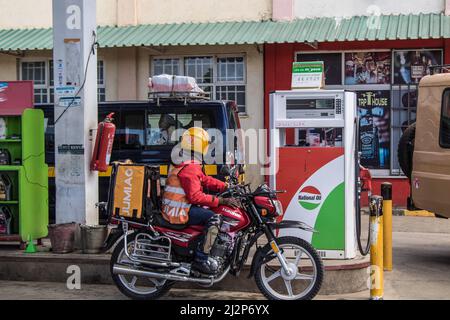 Nakuru, Kenia. 02. April 2022. Ein Motorradfahrer sah an einer Tankstelle der National Oil Corporation of Kenya warten, um Kraftstoff zu tanken. Kenia ist von einem großen Ölmangel heimgesucht worden, mit langen Warteschlangen von Autofahrern, die darauf warten, in einigen Tankstellen bedient zu werden, die noch immer das notwendige gut haben. Kenya Energy and Petroleum Regulatory (EPRA) führte den Mangel auf beispiellose logistische Herausforderungen zurück. Die globalen Ölpreise sind nach dem Krieg zwischen Russland und der Ukraine, der den Preis auf ein 14-jähriges hoch getrieben hat, beeinflusst worden. Kredit: SOPA Images Limited/Alamy Live Nachrichten Stockfoto