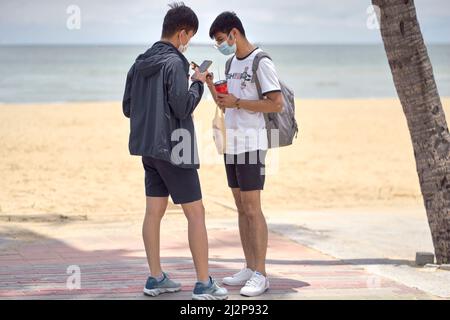 Smartphones für Menschen. Zwei junge Männer überprüfen ihre Smartphones im Freien Stockfoto