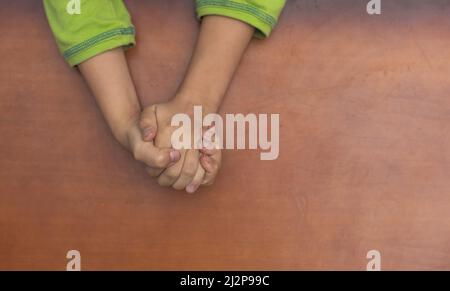 Die Hände des Kindes wurden im Gebet zusammengefaltet Stockfoto