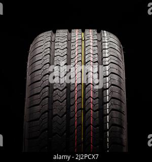 Ganzjahresfoto mit neuem Reifenquadrat auf schwarzem Hintergrund. Stockfoto