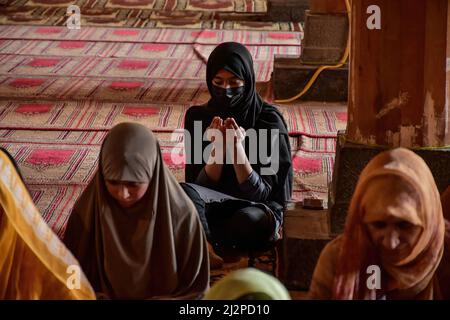 Srinagar, Indien. 03. April 2022. Am ersten Ramadan-Tag in Srinagar betet ein kaschmirischwischenes Mädchen in der Jamia Masjid oder der Großen Moschee. Muslime auf der ganzen Welt markieren den Monat Ramadan, den heiligsten Monat im islamischen Kalender, in dem Gläubige von Sonnenaufgang bis Sonnenuntergang fasten. Kredit: SOPA Images Limited/Alamy Live Nachrichten Stockfoto