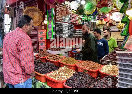 Srinagar, Indien. 03. April 2022. Ein Händler am Straßenrand verkauft Datteln und andere iftar-Artikel am ersten Tag des Ramadan in Srinagar. Muslime auf der ganzen Welt markieren den Monat Ramadan, den heiligsten Monat im islamischen Kalender, in dem Gläubige von Sonnenaufgang bis Sonnenuntergang fasten. Kredit: SOPA Images Limited/Alamy Live Nachrichten Stockfoto