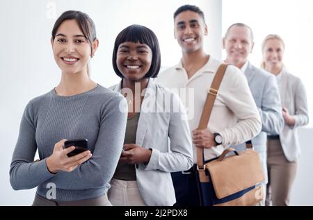 Das könnte unser Leben verändern. Aufnahme einer Gruppe neuer Mitarbeiter, die in einer Schlange warten, um ihr Interview abzuschließen. Stockfoto