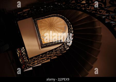 Lviv, Ukraine - 28. März 2022: Blick nach oben abstrakte Ansicht der alten dunklen Treppe im heruntergekommenen Apartmentgebäude in Lviv, Ukraine Stockfoto