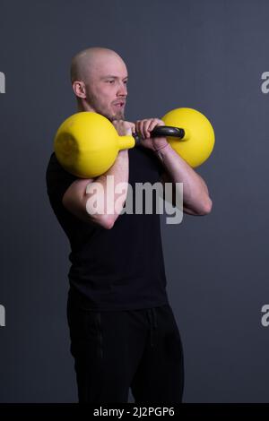 Kerl mit einem gelben Kettlebell Turnhalle anonymen gelben Mann, für sportliche Teenager für Kommissionierung für Gummi Gewichtheben, vietnamesische Fitness. Gesunder Daunen Stockfoto