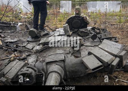 Kiew, Ukraine. 03. April 2022. Ukrainische Soldaten inspizieren einen zerstörten russischen Panzer während der russischen Invasion der Ukraine in Bucha, in der Nähe von Kiew, Ukraine am Sonntag, 3. April 2022. Foto von Vladyslav Musienko/UPI Credit: UPI/Alamy Live News Stockfoto