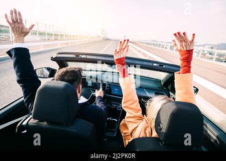 Ein Paar mittleren Alters, das auf einer Autoreise ein Auto fährt Stockfoto