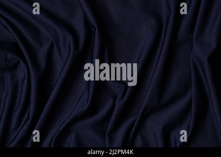 Sportbekleidung Stoff Textur Hintergrund. Marineblauer Stoff Sportbekleidung Fußballtrikot mit Air Mesh-Struktur Hintergrund. Draufsicht Stockfoto