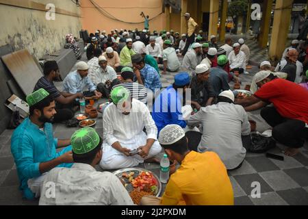 Kalkutta, Indien. 03. April 2022. Muslimische Männer warten während des Fastenmonats Ramadan in Kalkutta auf ihre Iftar-Mahlzeiten in einer Moschee. (Foto von Sudipta das/Pacific Press) Quelle: Pacific Press Media Production Corp./Alamy Live News Stockfoto